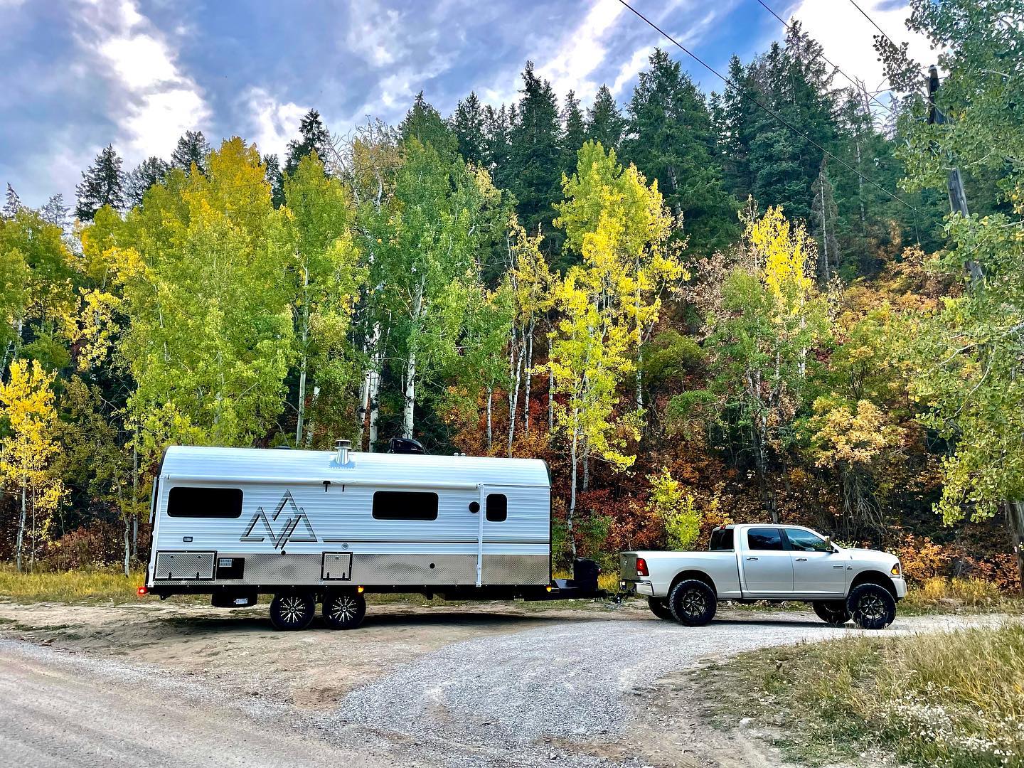 silver truck pulling a peak mountain camp in the fall