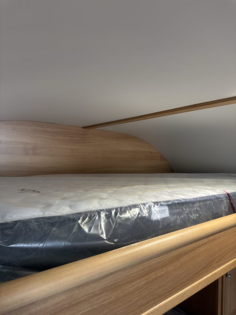 East-west upper bunk above the queen bed.