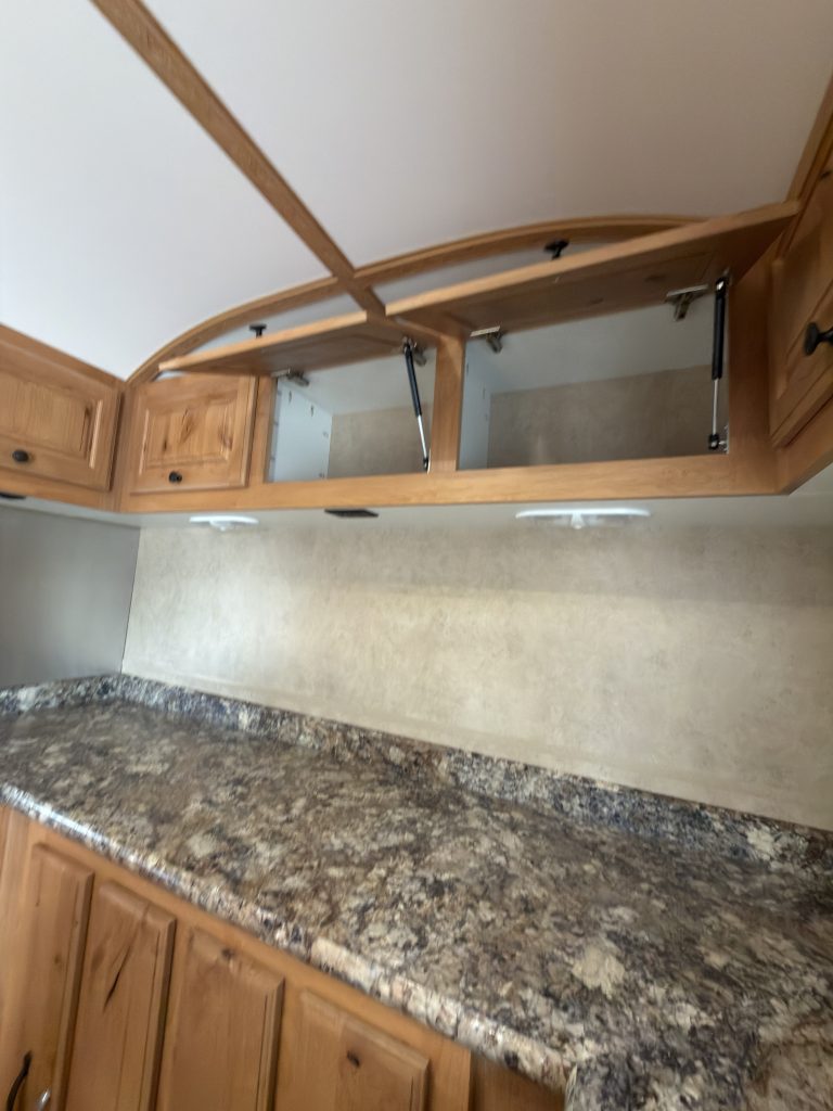 Detail view of Gas-Strut Overhead Cabinets in the Schrauth Camp.