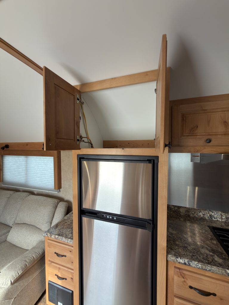 Open microwave cabinet in the Schrauth Camp kitchen.