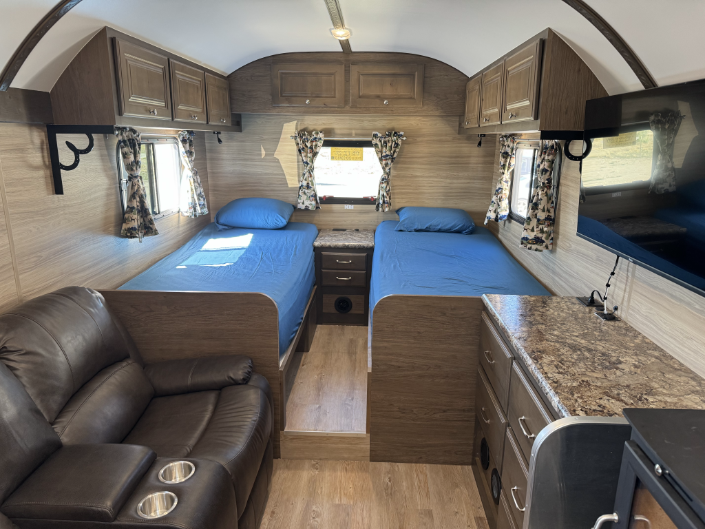 Interior of the Heikell Camp featuring twin beds, custom cabinetry, and a reclining chair