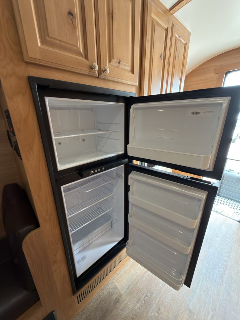 Four-door propane-electric refrigerator and freezer shown open.