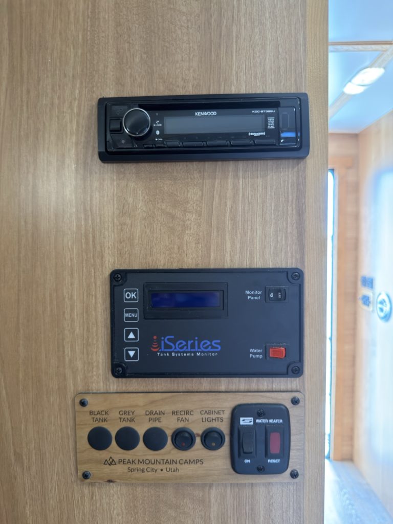 Stereo head unit and tank-monitor controls on a wood panel.