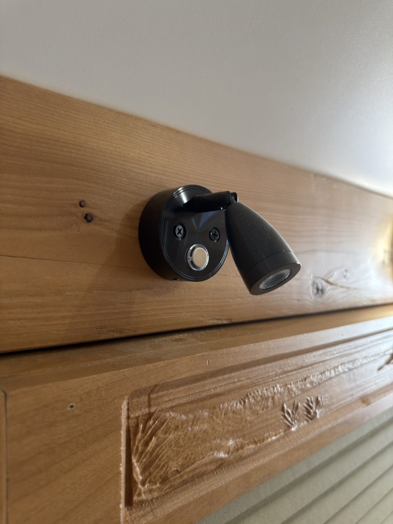 Black USB reading light mounted above carved wood trim.