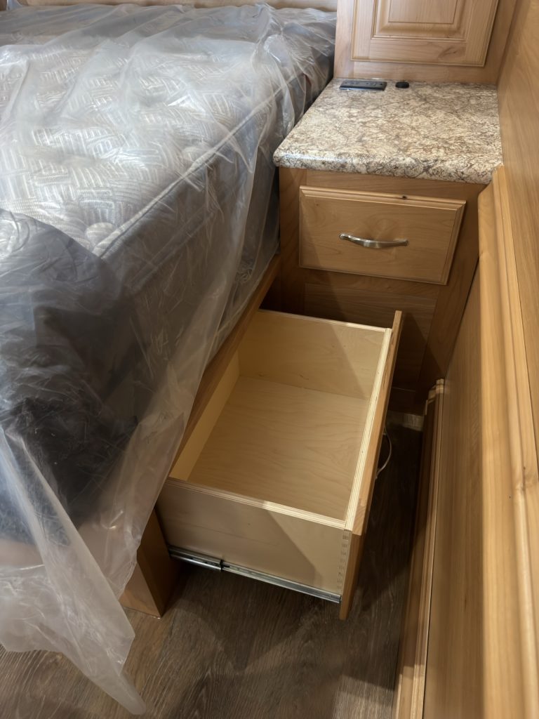 Open dovetail drawer beneath the bed.