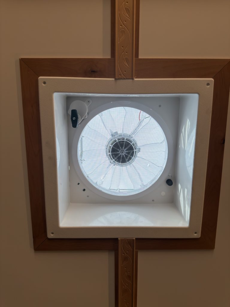 Square Fantastic Fan framed by carved rosewood ceiling trim.