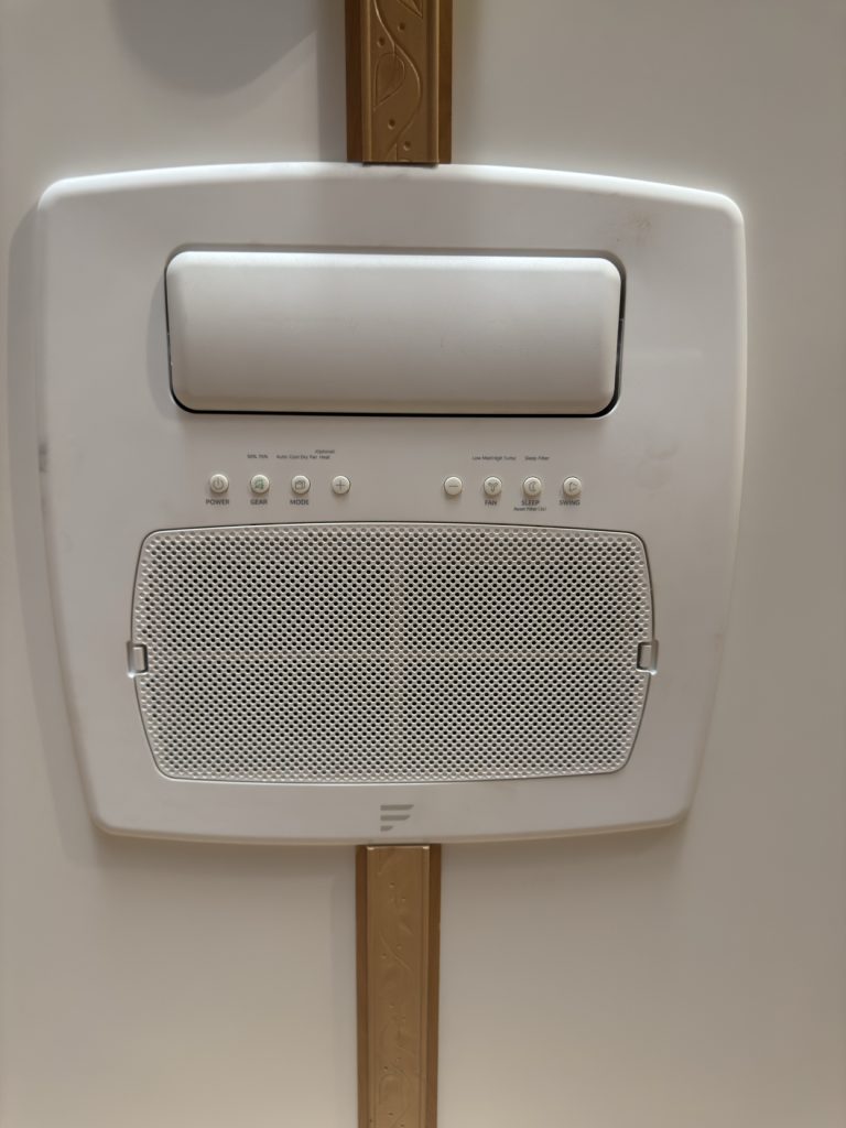 White Furrion ceiling-mounted air conditioner and control panel.