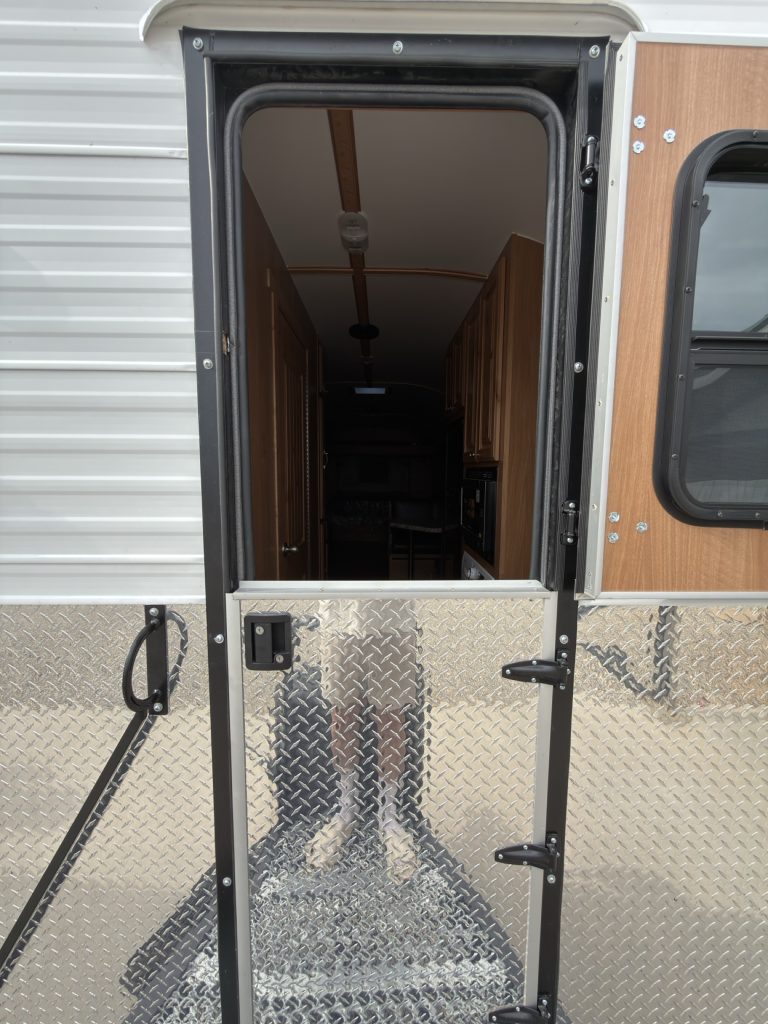 Dutch entry door open above the metal landing and fold-up steps.