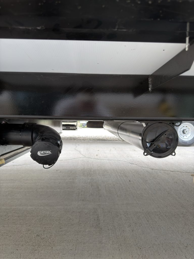 Waste water hose storage and connection beneath the rear frame.
