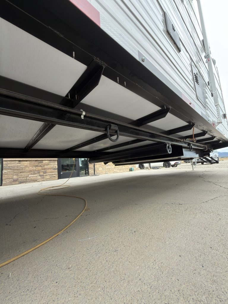 Black steel chassis rails viewed beneath the trailer.