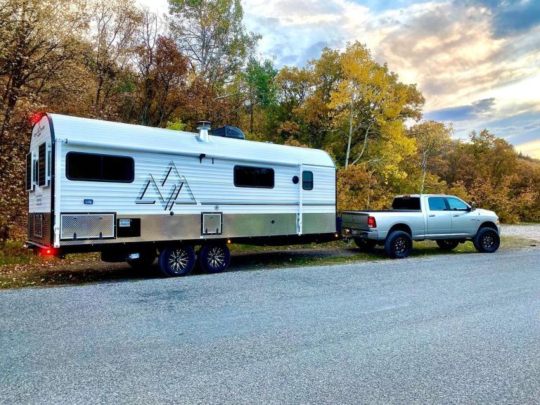 Peak camp and tow vehicle among autumn trees