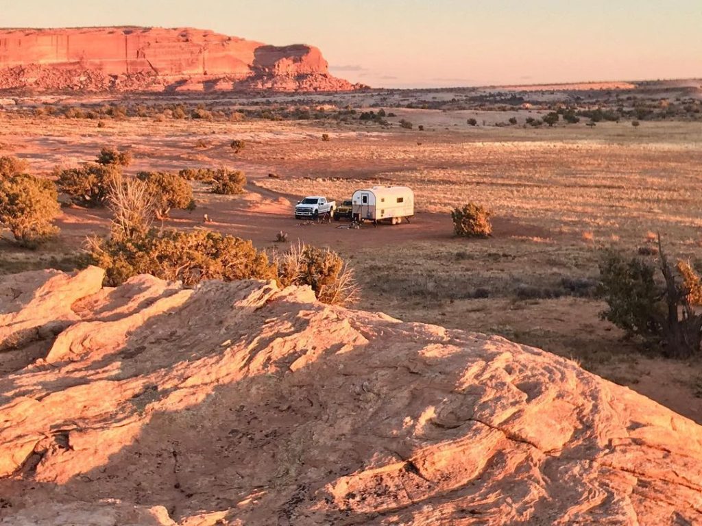 Distant Peak camp trailer surrounded by red-rock desert terrain