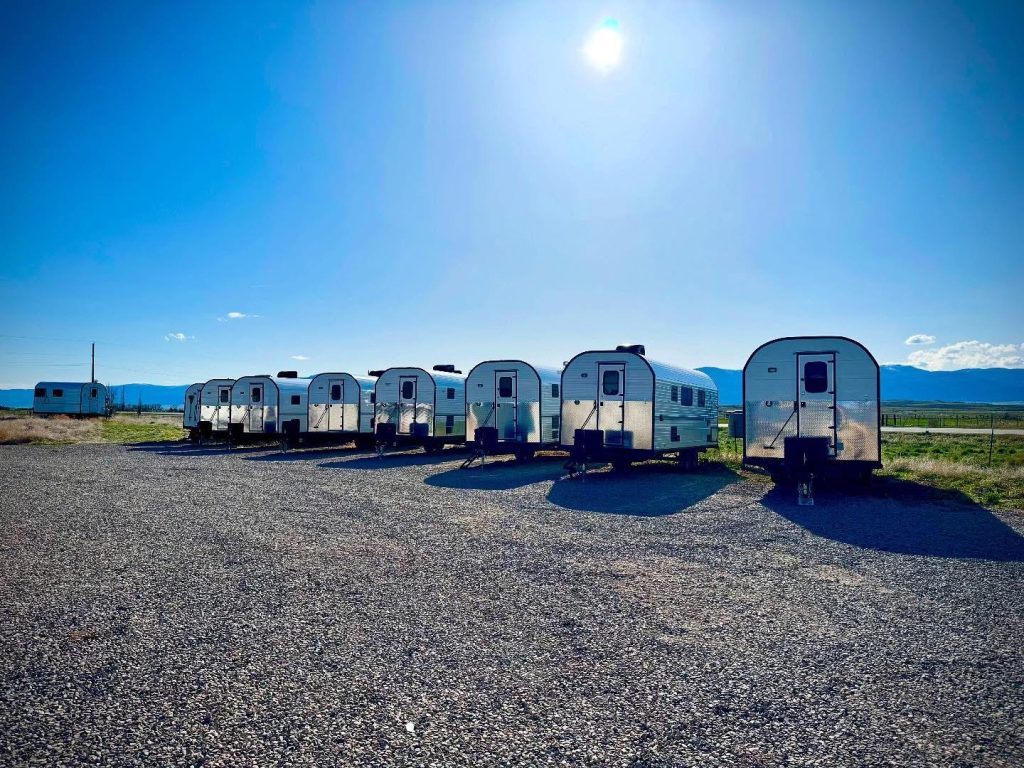 Multiple completed Peak camp trailers lined up outside the workshop
