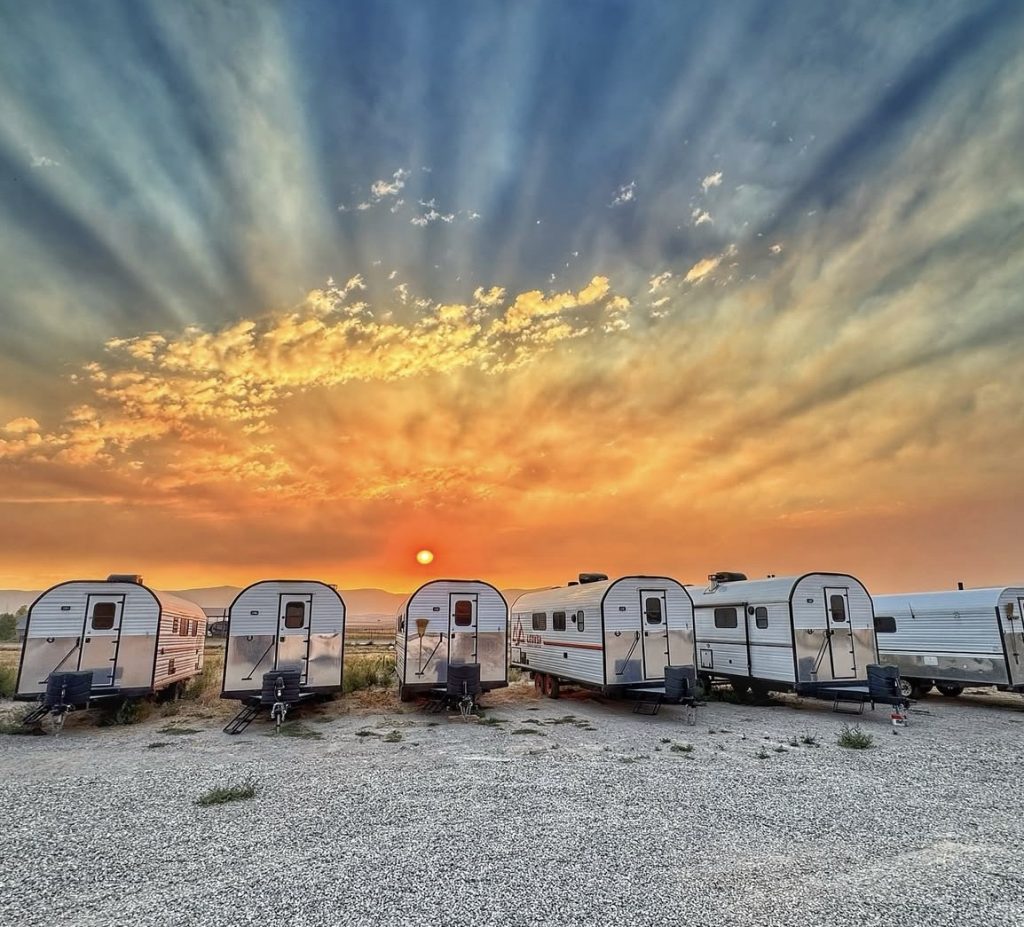 Peak Camps Lined Up Beneath a Sunset