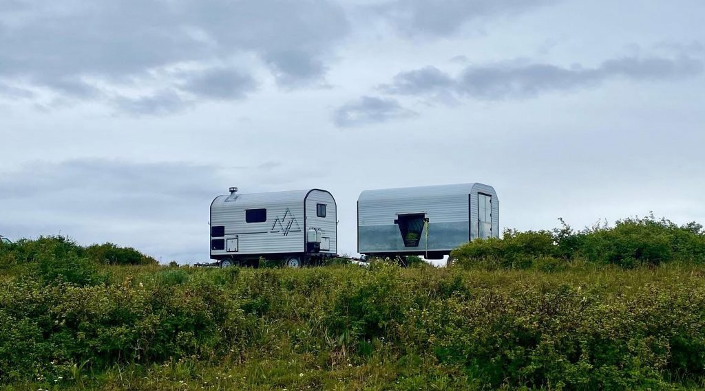 Two herder camps in a mountain open-range area beneath a cloudy sky