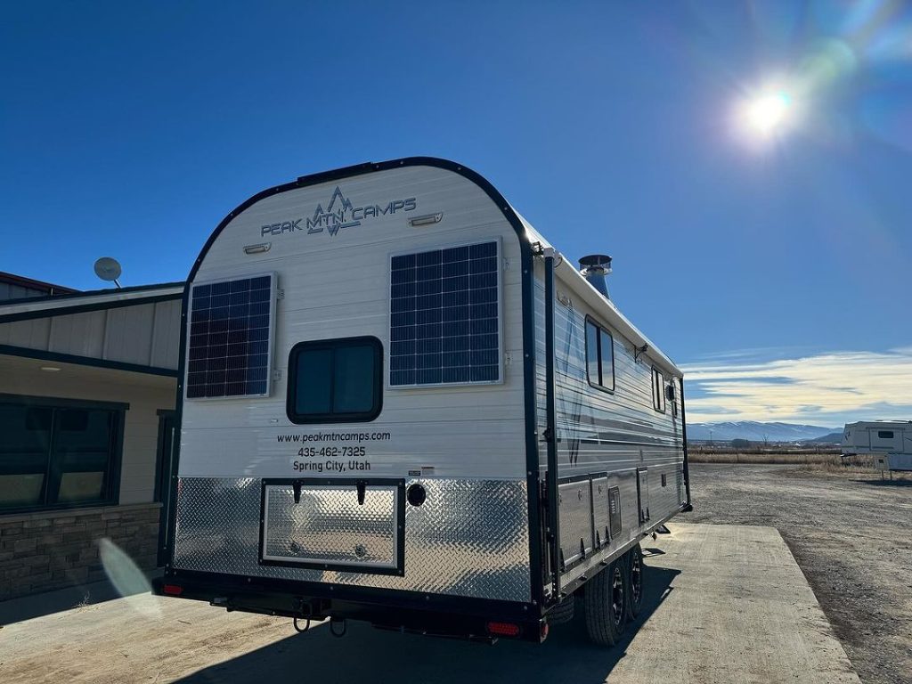 Rear exterior view of a Peak camp trailer displayed outside the workshop