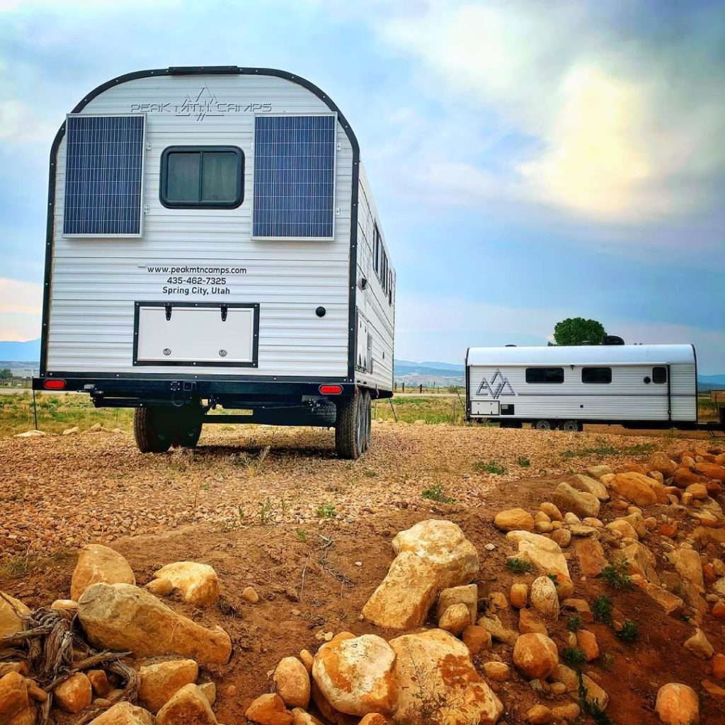 Rear exterior of a custom Peak camp trailer displayed on rocky ground