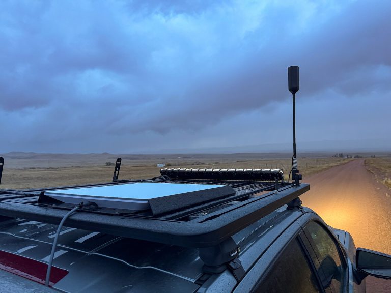 Starlink flat-panel terminal mounted on an overlanding vehicle in remote terrain