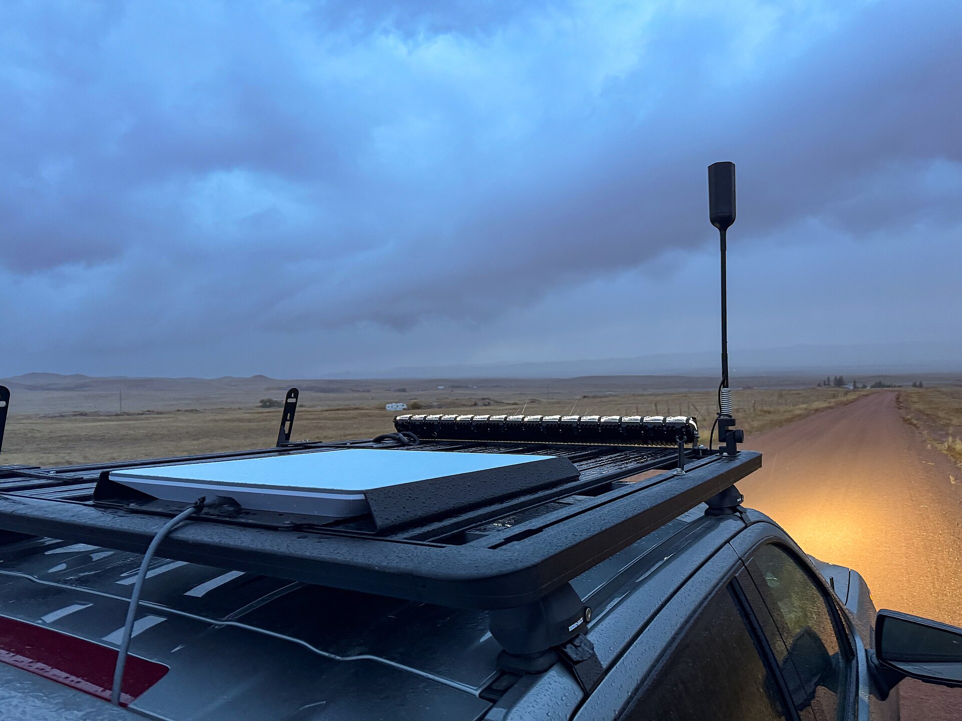 Starlink flat-panel terminal mounted on an overlanding vehicle in remote terrain