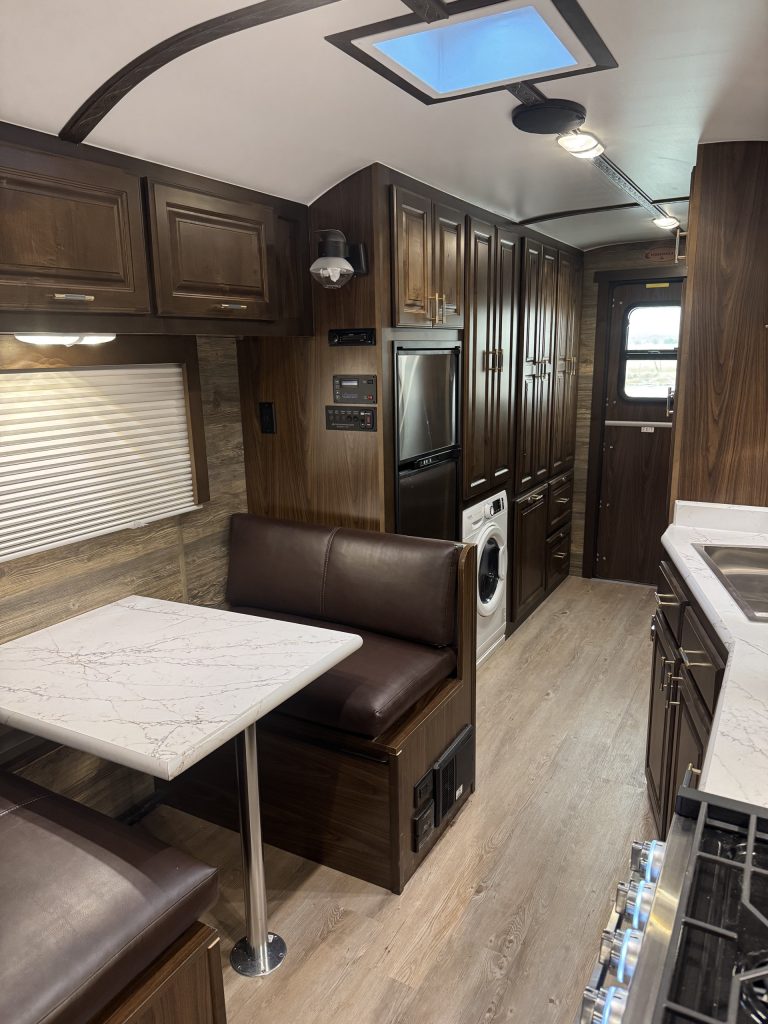 North/south bed, kitchen, dinette, and hardwood cabinetry inside the untitled X35 camp