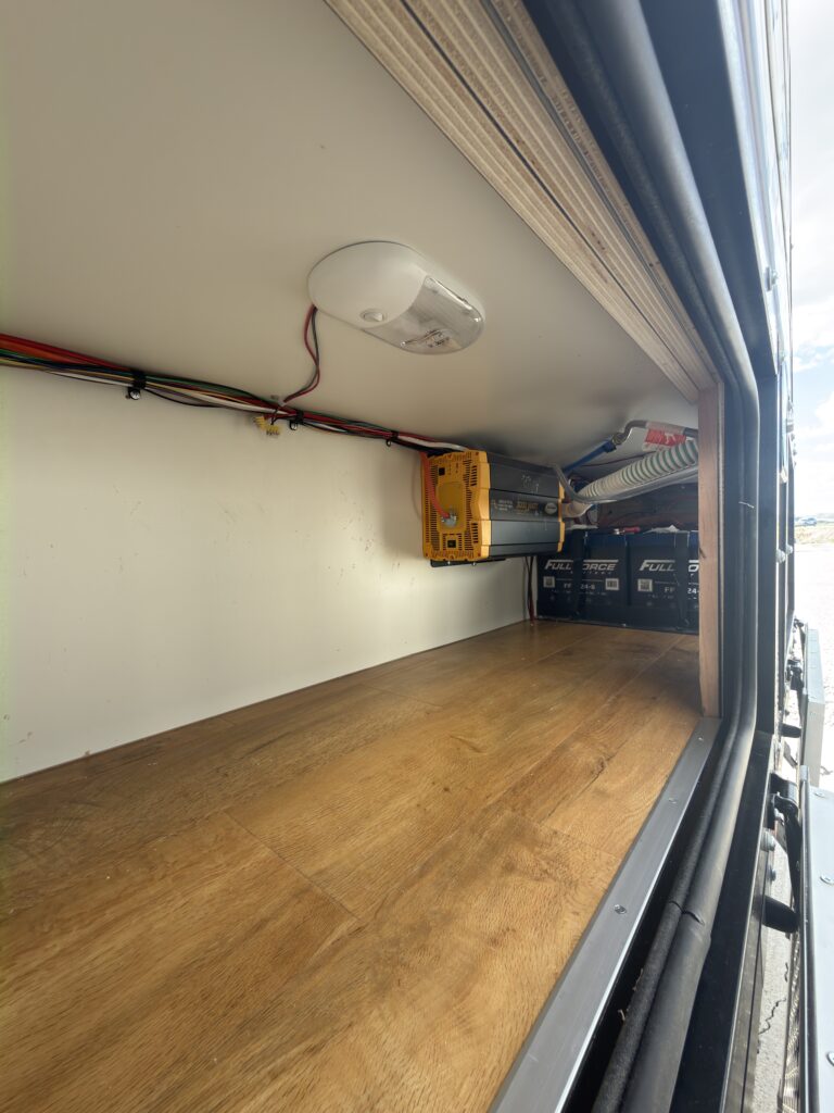 Image of the large exterior storage compartment with electrical utilities, battery bank, and solar controller of Gail Camp #131.