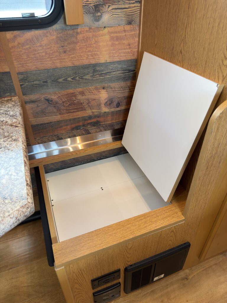 Image of the open dinette bench storage of Gail Camp #131.