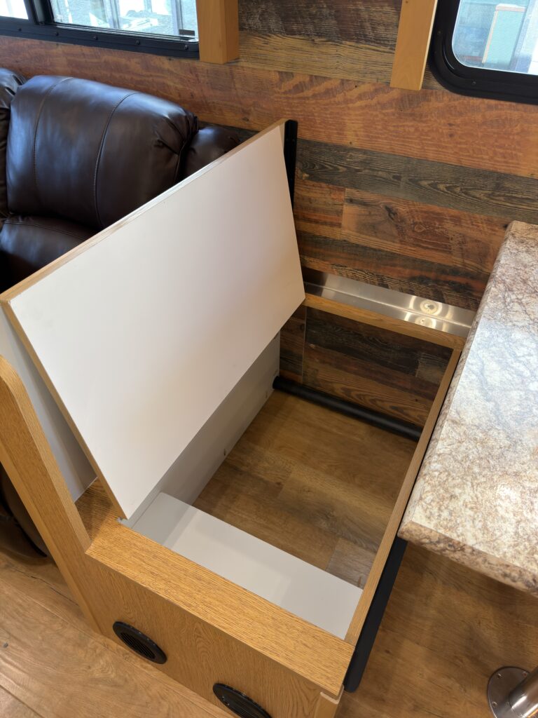 Image of the dinette bench storage compartment of Gail Camp #131.