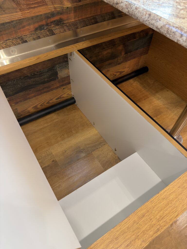 Image of the deep storage compartment beside dinette of Gail Camp #131.