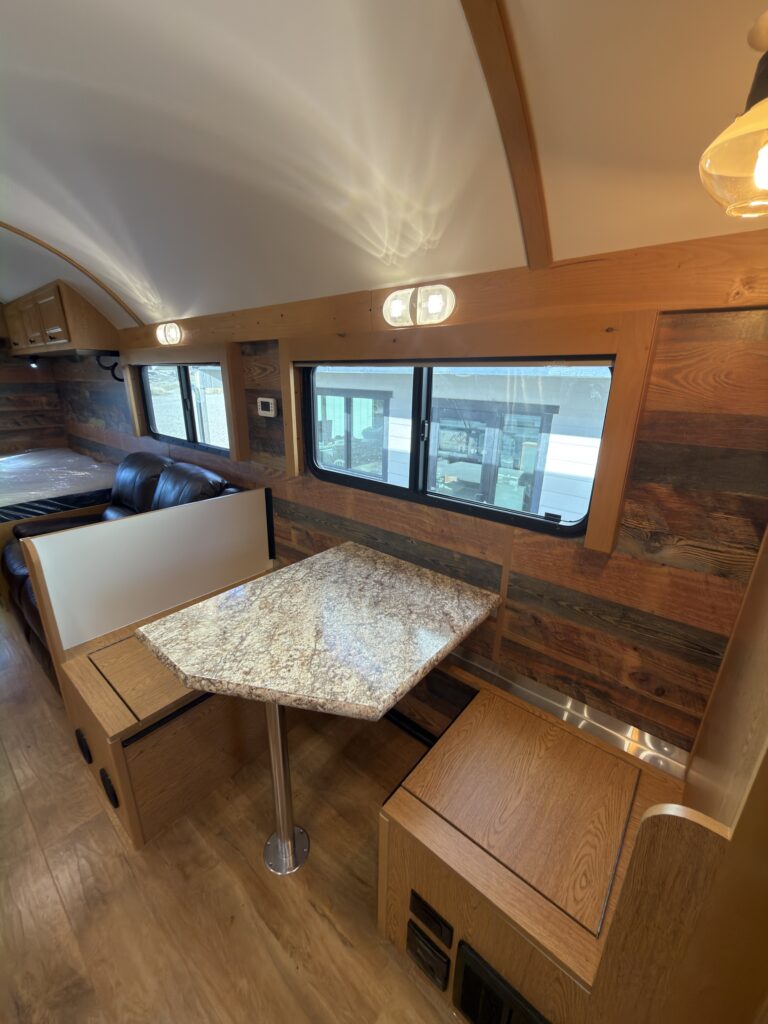 Image of the dinette table and bench storage of Gail Camp #131.