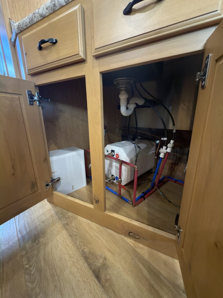Image of the open plumbing access cabinet of Gail Camp #131.