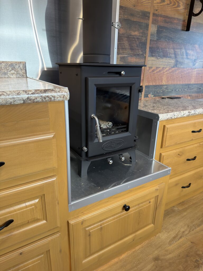 Image of the wood stove and lower cabinetry of Gail Camp #131.
