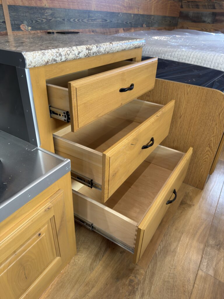 Image of the open entertainment center drawers of Gail Camp #131.