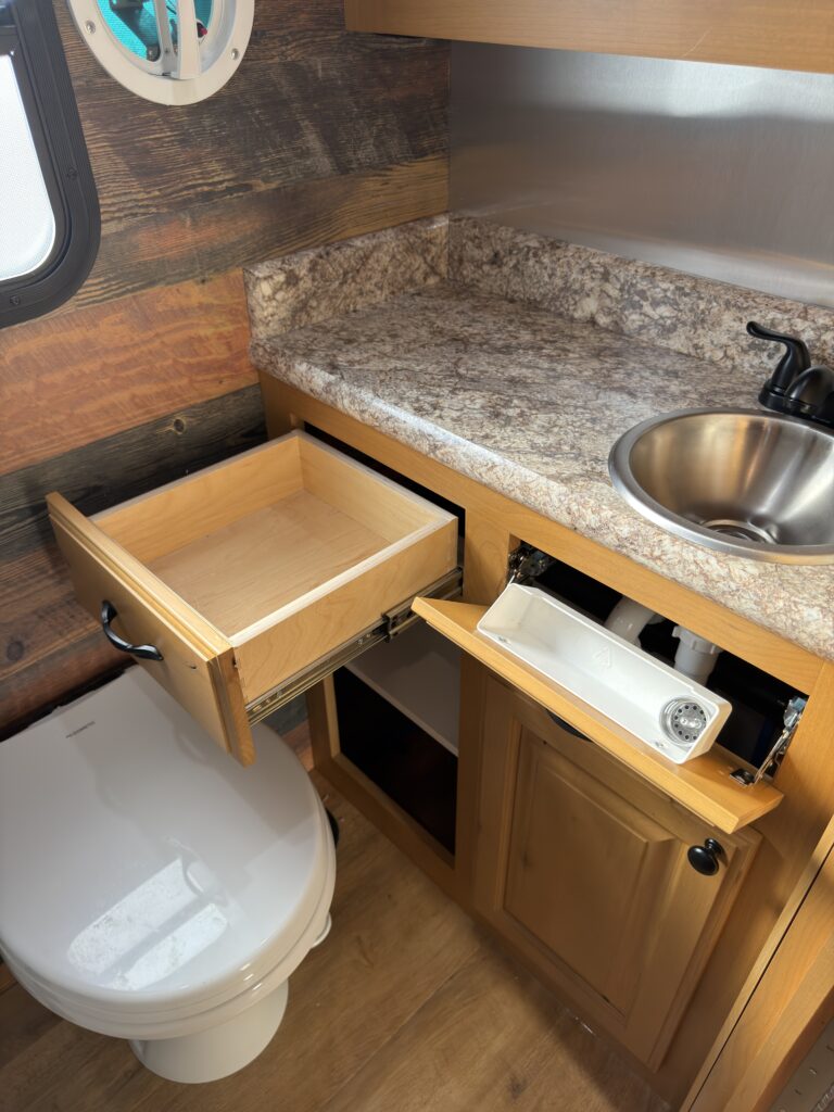 Image of the open bathroom vanity storage of Gail Camp #131.