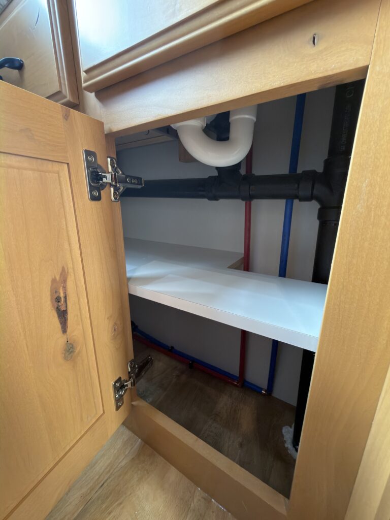 Image of the bathroom sink plumbing and shelves of Gail Camp #131.