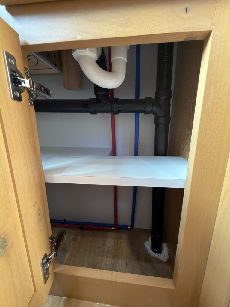 Image of the bathroom plumbing access with shelving of Gail Camp #131.