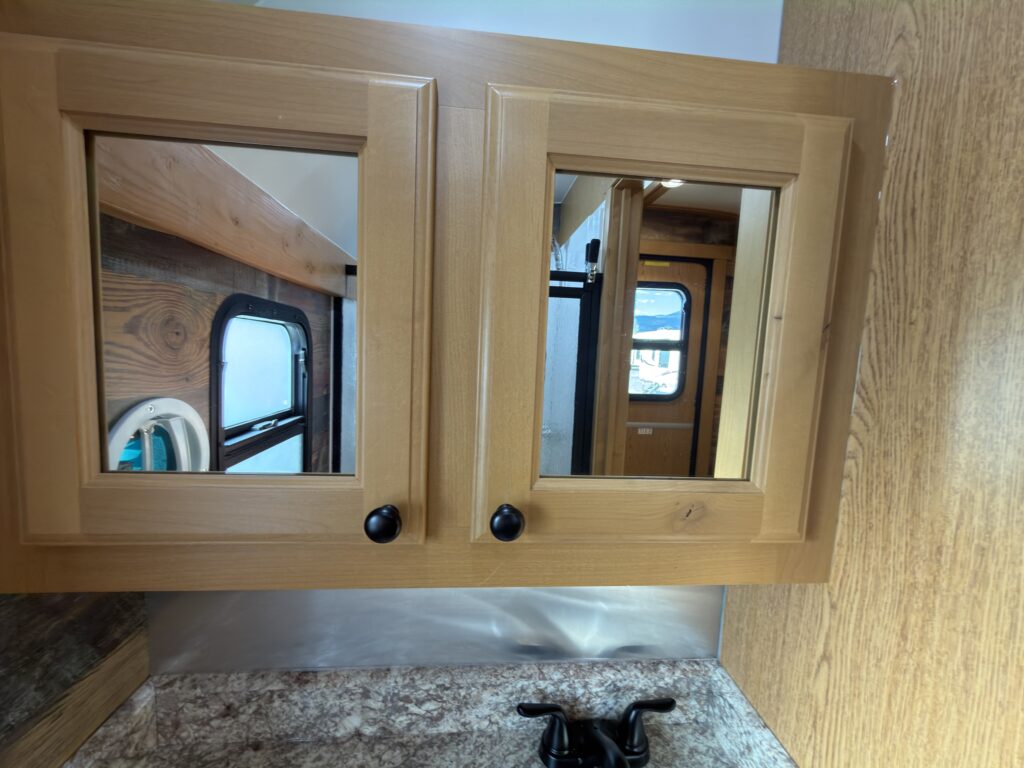 Image of the mirrored bathroom cabinets of Gail Camp #131.