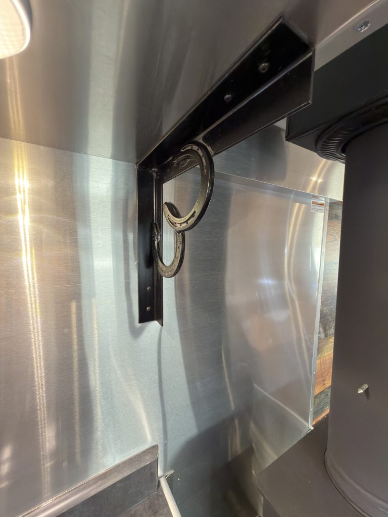 Horseshoe Bracket Accent beside Wood Stove Chimney in Nielsen Camp #133