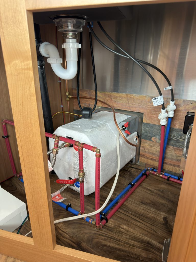 Under-Sink Plumbing and Water Heater - Wide View in Nielsen Camp #133