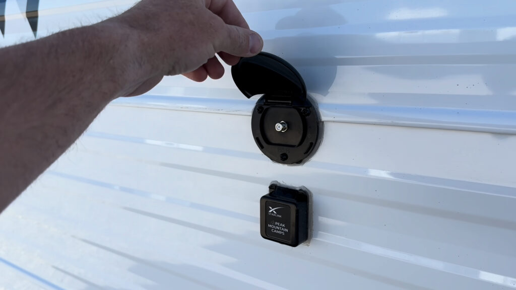 Open coax fitting above a covered Starlink-labeled RJ45 Ethernet port on Plankis Camp #124.