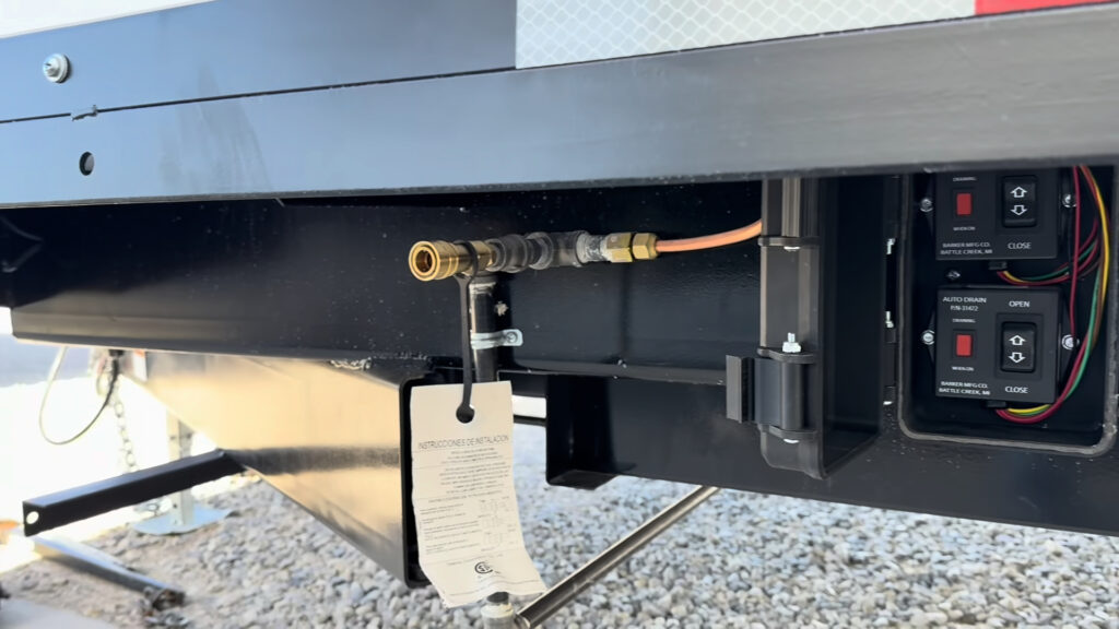 Road-side propane quick-connect beside the open waste gate control enclosure underneath Plankis Camp #124.