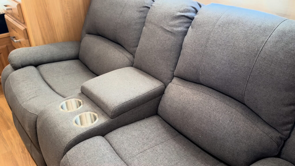 Two-seat reclining loveseat with a padded center console and two cup holders in Plankis Camp #124.