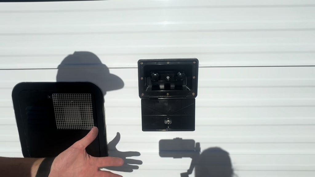 Exterior shower and spray port on the white sidewall beside a vent.