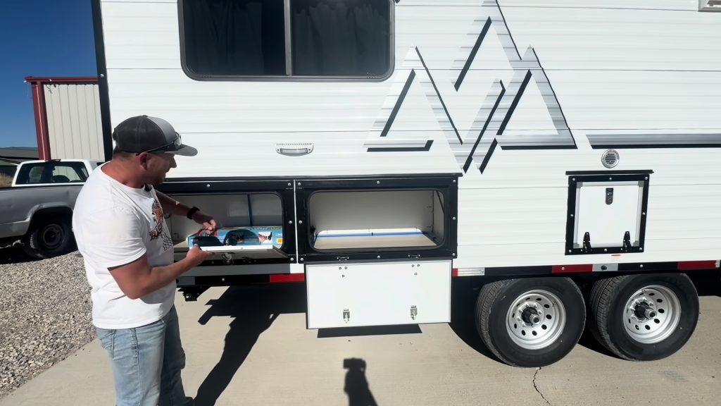 Open exterior side compartment with a presenter beside the dual-axle camp.