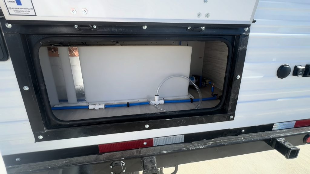 Second view into the rear compartment with water lines and fittings.