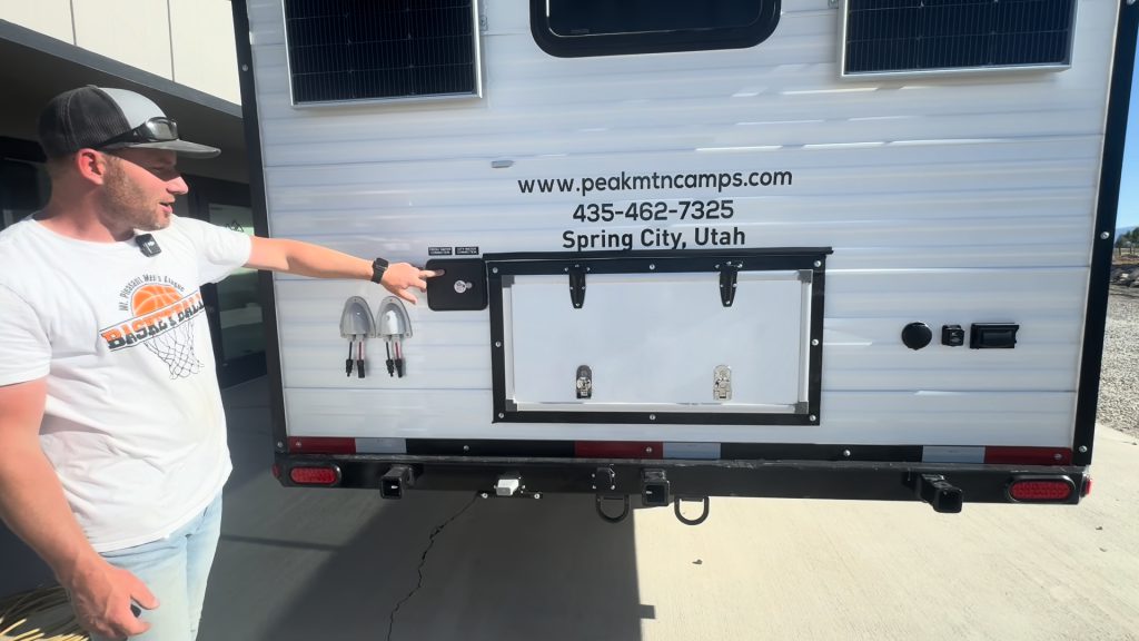 Presenter pointing to storage hatches across the rear side of the camp.