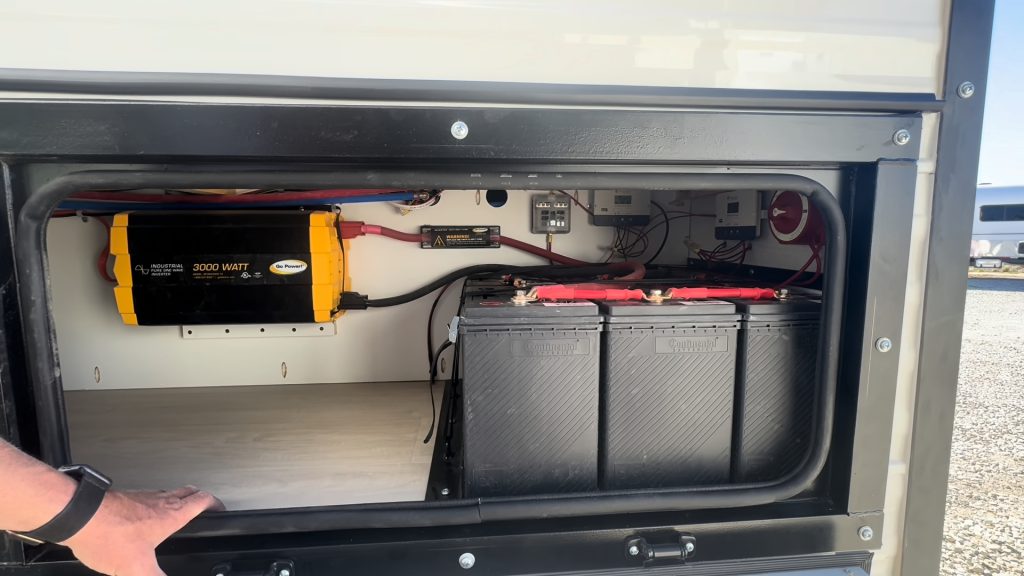 Open exterior compartment with batteries and electrical equipment.