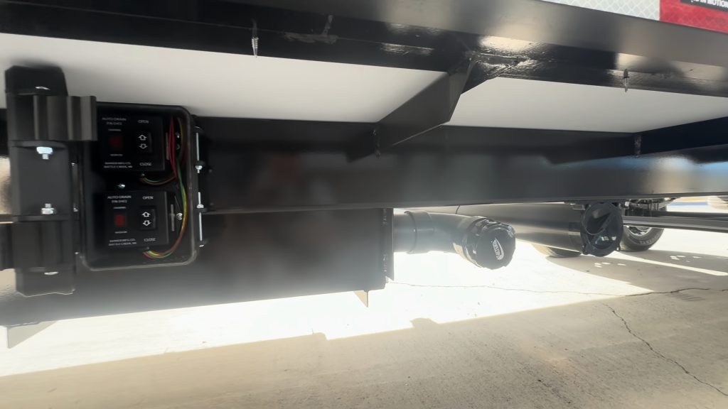 Low view of the camp's underbody components near the rear frame.