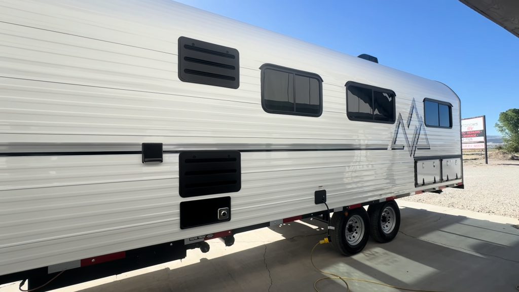 Roadside profile of the white Hanson Camp with dual axles and side windows.