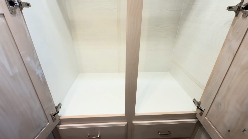 Open storage area and drawers in the entry hallway wardrobe.