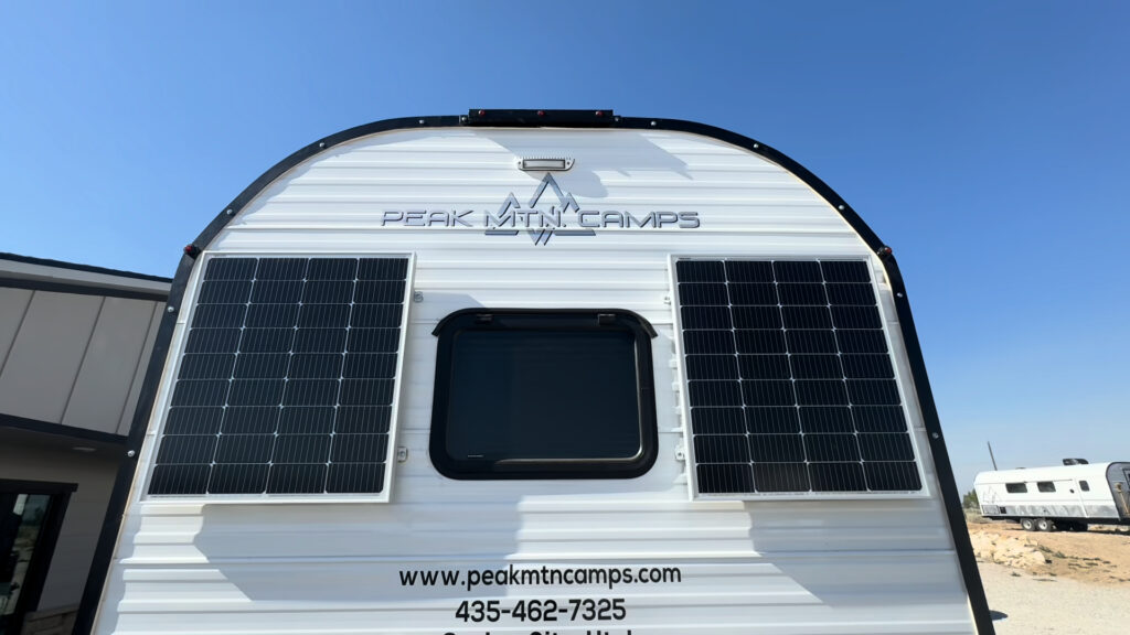 Straight-on view of two solar panels flanking the rear window of the Kendall Camp.